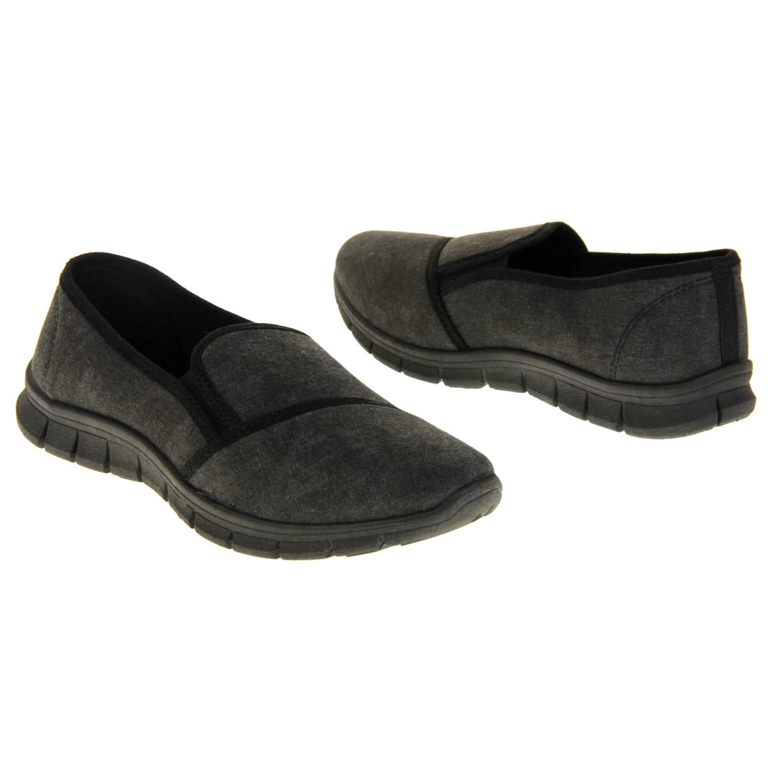 Comfortable black work shoes. Slip on plimsoll style shoes with a black canvas upper. Black elasticated gusset. Chunky black sole. Both feet at an angle facing top to tail.