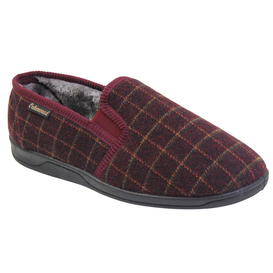 Comfy mens slippers. Full back slippers with burgundy wool effect upper with orange check. Red elasticated panels joining the tongue to the top of the slippers. Small black label on the outside rim, with Oakenwood branding sewn in gold. Grey faux fur lining. Right foot at an angle.