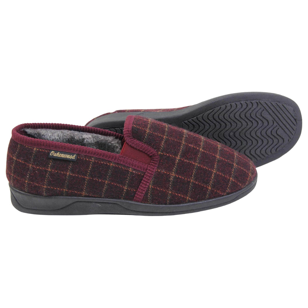 Comfy mens slippers. Full back slippers with burgundy wool effect upper with orange check. Red elasticated panels joining the tongue to the top of the slippers. Small black label on the outside rim, with Oakenwood branding sewn in gold. Grey faux fur lining. Both feet from side profile with left foot on its side to show the sole.