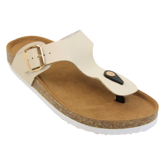 Cream flip flops. Cream faux leather strap with toe post to the front and gold buckle to the outside. Soft tan faux suede footbed with cork effect outsole and white sole. Right foot at an angle.