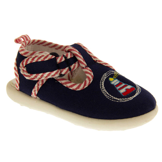 Boys sandals. Navy canvas sandals with cut out heel. White sole with lighthouse detail on the front of the shoes and red and white striped edging. Right foot at angle.