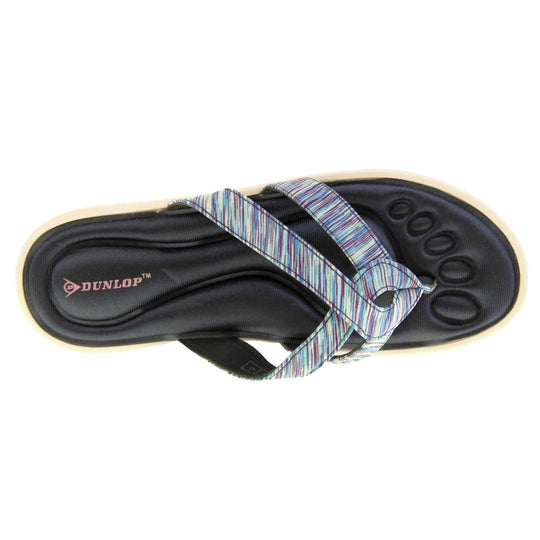 Dunlop flip flops. Womens flip flops with two straps done in a purple, teal and blue textile material meeting at a toe post. Black moulded, cushioned insole with white sole. Birdseye view of left foot.