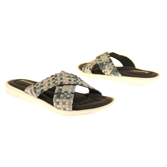 Womens black flat sandals - Black and grey mosaic style crossover straps with a dense black memory foam insole - perfect comfy sandals for women. White outsole. Both feet facing different directions.