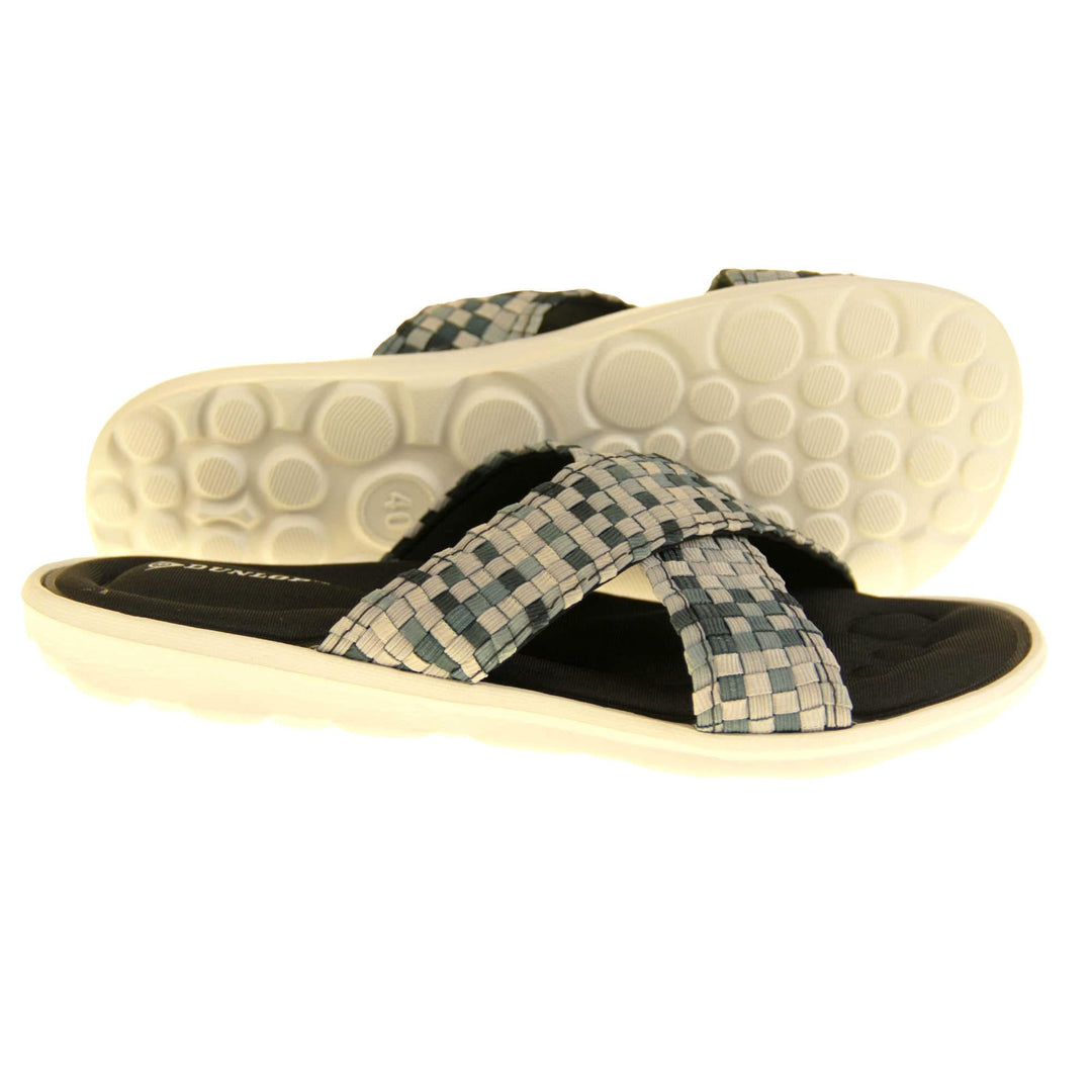 Womens black flat sandals - Black and grey mosaic style crossover straps with a dense black memory foam insole - perfect comfy sandals for women. White outsole. Right foot side on and left foot tilted showing circular grips to white outsole.