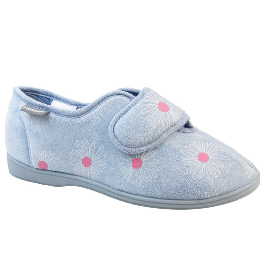 Slippers for swollen feet. Womens full back slipper. With a pale blue upper with white daisy design with bright pink for the middle of the flowers. Touch fasten strap over the top of the foot to adjust the fit. Matching blue textile lining and sole. Right foot at an angle.