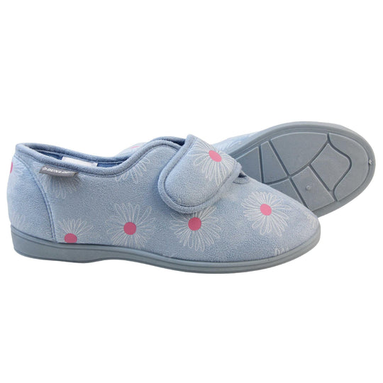 Slippers for swollen feet. Womens full back slipper. With a pale blue upper with white daisy design with bright pink for the middle of the flowers. Touch fasten strap over the top of the foot to adjust the fit. Matching blue textile lining and sole. Both feet from a side profile with the left foot on its side behind the the right foot to show the sole.