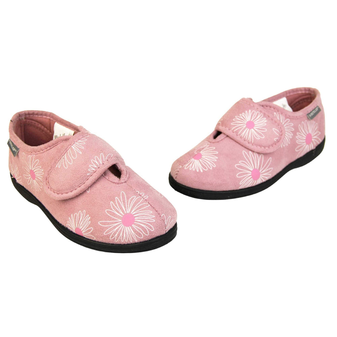 Adjustable slippers womens. Ladies full back slipper. Pale pink upper with white daisy design and bright pink for the middle of the flowers. Touch fasten strap over the top of the foot to adjust the fit. Matching pink textile lining and firm black sole. Both feet in a V shape with toes almost touching.