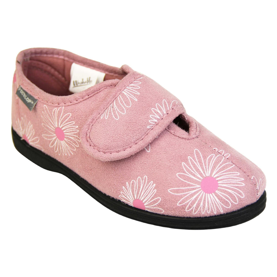 Adjustable slippers womens. Ladies full back slipper. Pale pink upper with white daisy design and bright pink for the middle of the flowers. Touch fasten strap over the top of the foot to adjust the fit. Matching pink textile lining and firm black sole. Right foot at an angle.