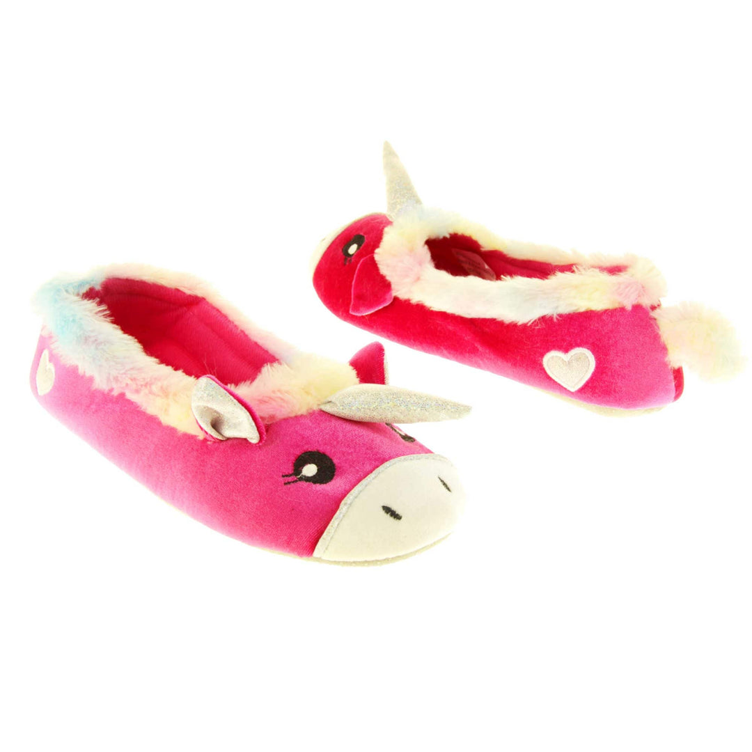 Unicorn slippers womens. Ladies slippers in a ballerina style. With bright pink velvety upper, cute embroidered horse face,shiny horn and rainbow faux fur collar. Warm pink lining. Beige textile sole with bumps to the bottom for grip. Both feet at an angle, facing top to tail.