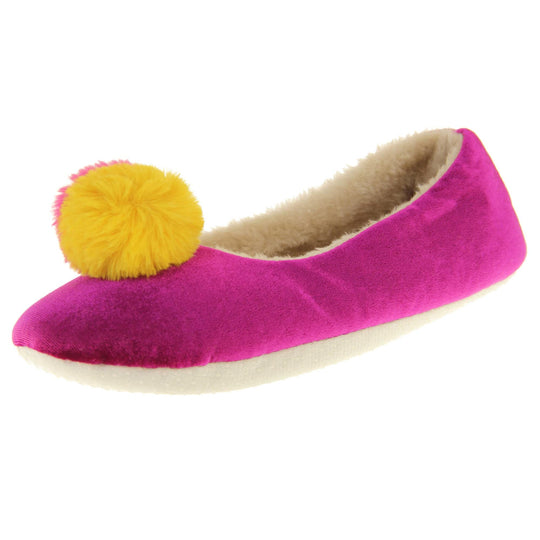Womens ballet slippers. Ladies slippers in a ballerina style. Fuchsia velvety upper with fluffy yellow and pink pom pom on the top. Cream faux fur lining. Beige textile sole with bumps to the bottom for grip. Left foot at an angle.
