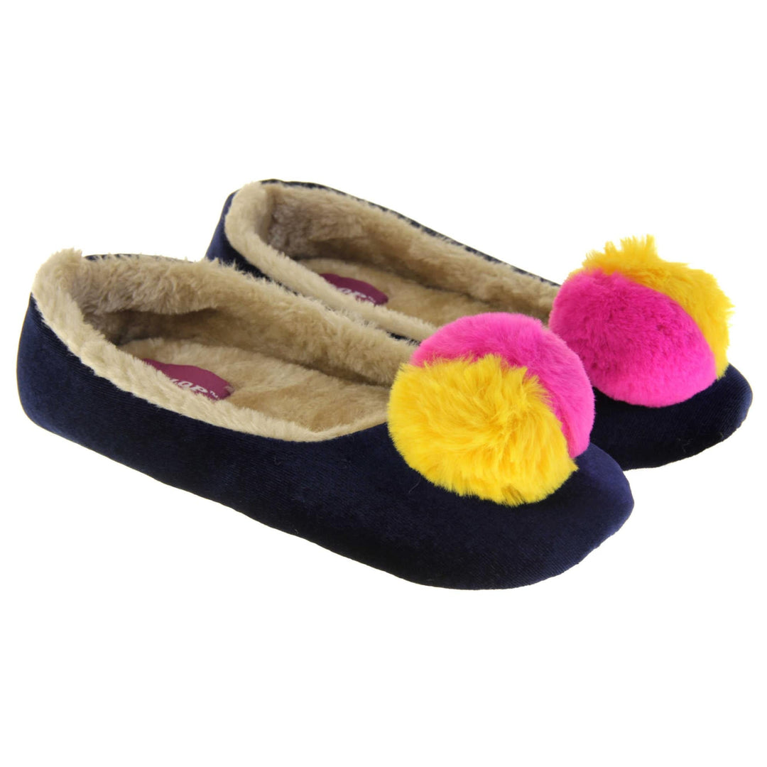 Womens ballerina slippers. Ladies slippers in a ballerina style. Navy blue velvety upper with fluffy yellow and pink pom pom on the top. Cream faux fur lining. Beige textile sole with bumps to the bottom for grip. Both feet together at an angle.