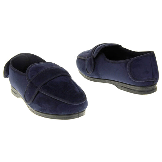 Extra wide fit slippers for men. Full back slippers with navy blue upper. Adjustable touch fasten strap to the top of the foot and around the back of the heel. Navy textile lining. Firm black sole. Both feet from a slight angle about an inch apart from each other facing top to tail.