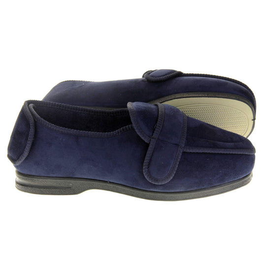 Extra wide fit slippers for men. Full back slippers with navy blue upper. Adjustable touch fasten strap to the top of the foot and around the back of the heel. Navy textile lining. Firm black sole. Both feet from side profile with left foot on its side to show the sole.