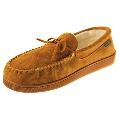 Faux fur moccasins. Closed back slippers in a moccasin style with tan brown suede leather upper and bow. Cream faux fur lining. Thick brown sole. Left foot at an angle.