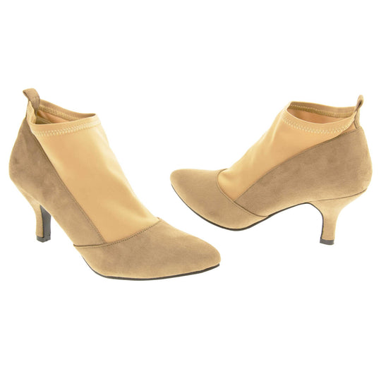 Faux suede ankle boots. Womens taupe faux suede ankle boot with a stretchy nude fabric panel to the front and around the top of the ankle. Small faux suede loop to the back for pulling onto your feet. Small taupe faux suede heel and black sole. Both feet at an angle facing top to tail.