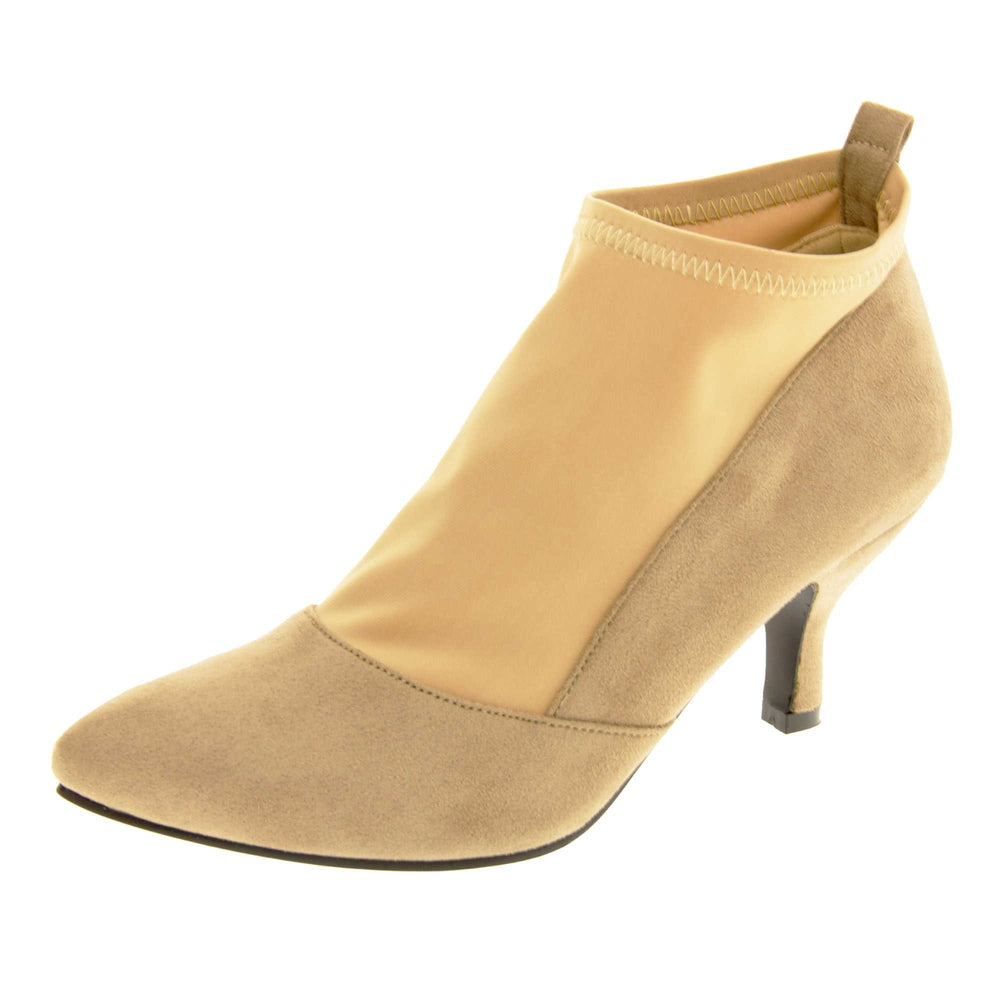 Faux suede ankle boots. Womens taupe faux suede ankle boot with a stretchy nude fabric panel to the front and around the top of the ankle. Small faux suede loop to the back for pulling onto your feet. Small taupe faux suede heel and black sole. Left foot at an angle.