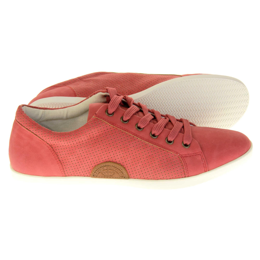 Faux suede sneakers. Women's shoes in a sneaker trainer style with a red faux suede upper. Tiny dot cut-out detailing to the side of the shoe. Red laces and a brown half-circle to the side of the shoe with Keddo branding on it. White leather lining and sole. Both feet from a side profile with the left foot on its side behind the the right foot to show the sole.