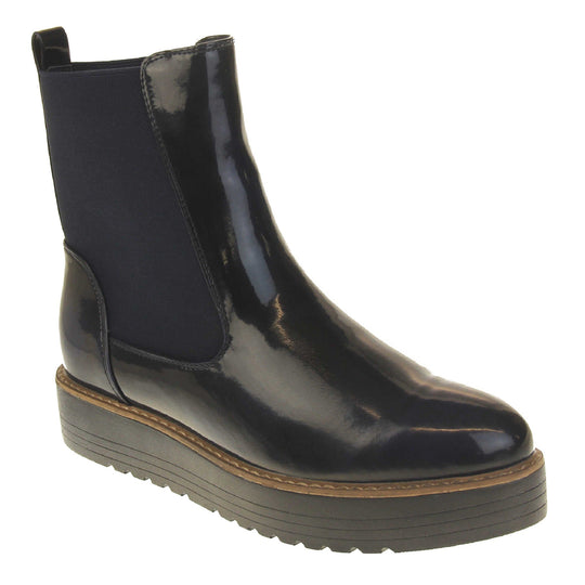 Fleece lined boots women's. Faux leather, tall Chelsea boot style with a black upper. Black elasticated panels at the ankles and a black loop at the heel to help pull them on. Black coloured low platform sole. Right foot at an angle