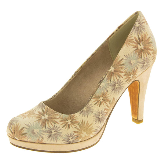 Floral heels. Womens court shoes with a cream upper with faded floral multi coloured pattern. Matching insole with Marco Tozzi branding. Taupe faux suede lining. Small cream platform and mid stiletto heel. Brown sole. Left foot at an angle.