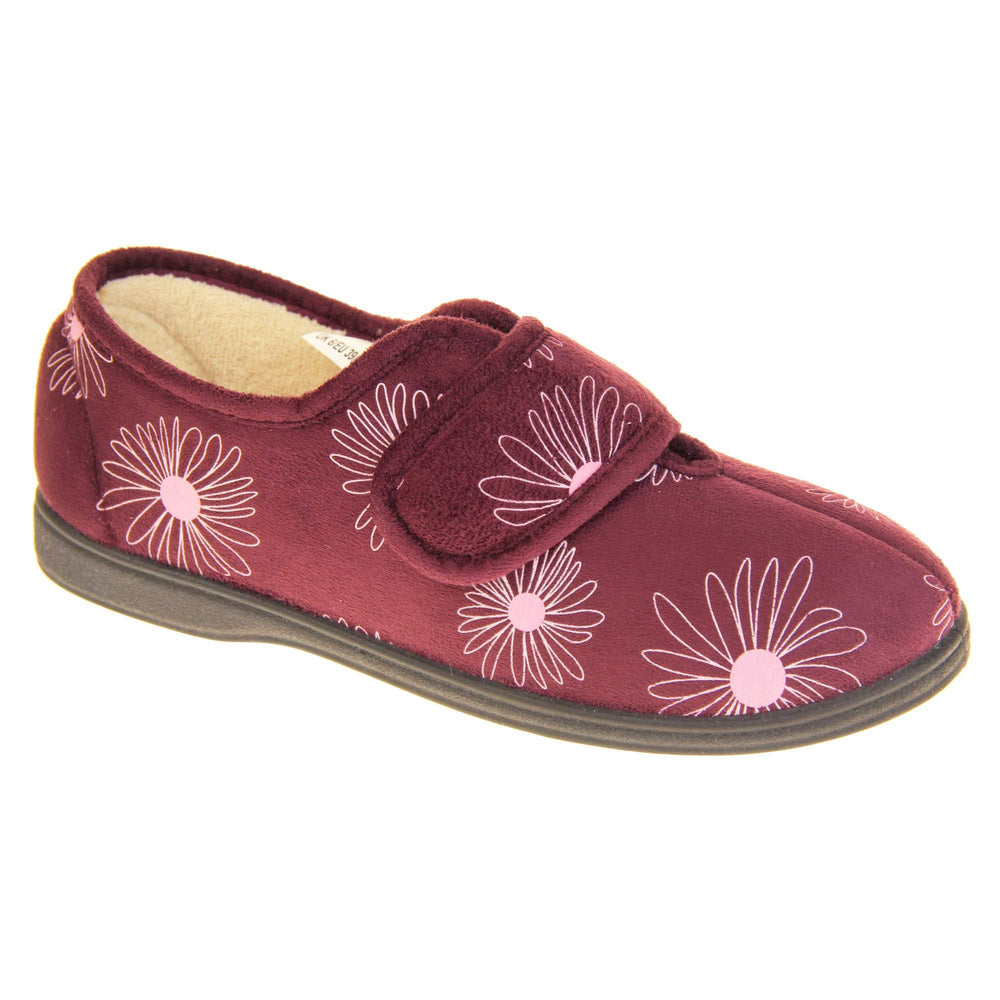 Floral slippers. Womens full back slipper. Burgundy upper with white daisy design and bright pink for the middle of the flowers. Touch fasten strap over the top of the foot to adjust the fit. Cream fleece lining and firm black sole. Right foot at an angle.