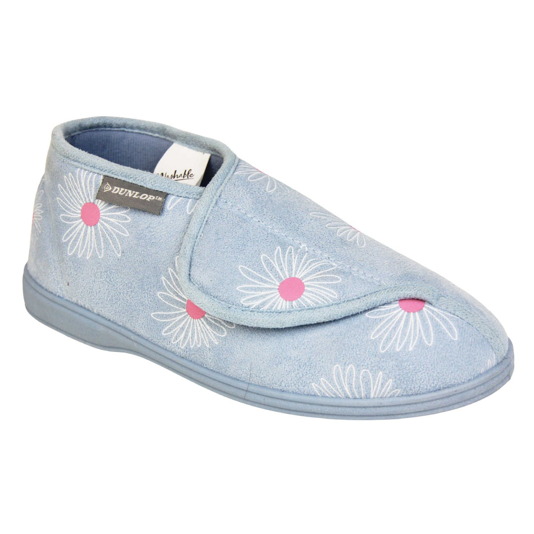 Flower slippers. Womens bootie style slipper with a pale blue textile upper with a white and pink flower print. Touch fasten tab to the top and blue textile lining. Firm blue sole. Right foot at an angle.