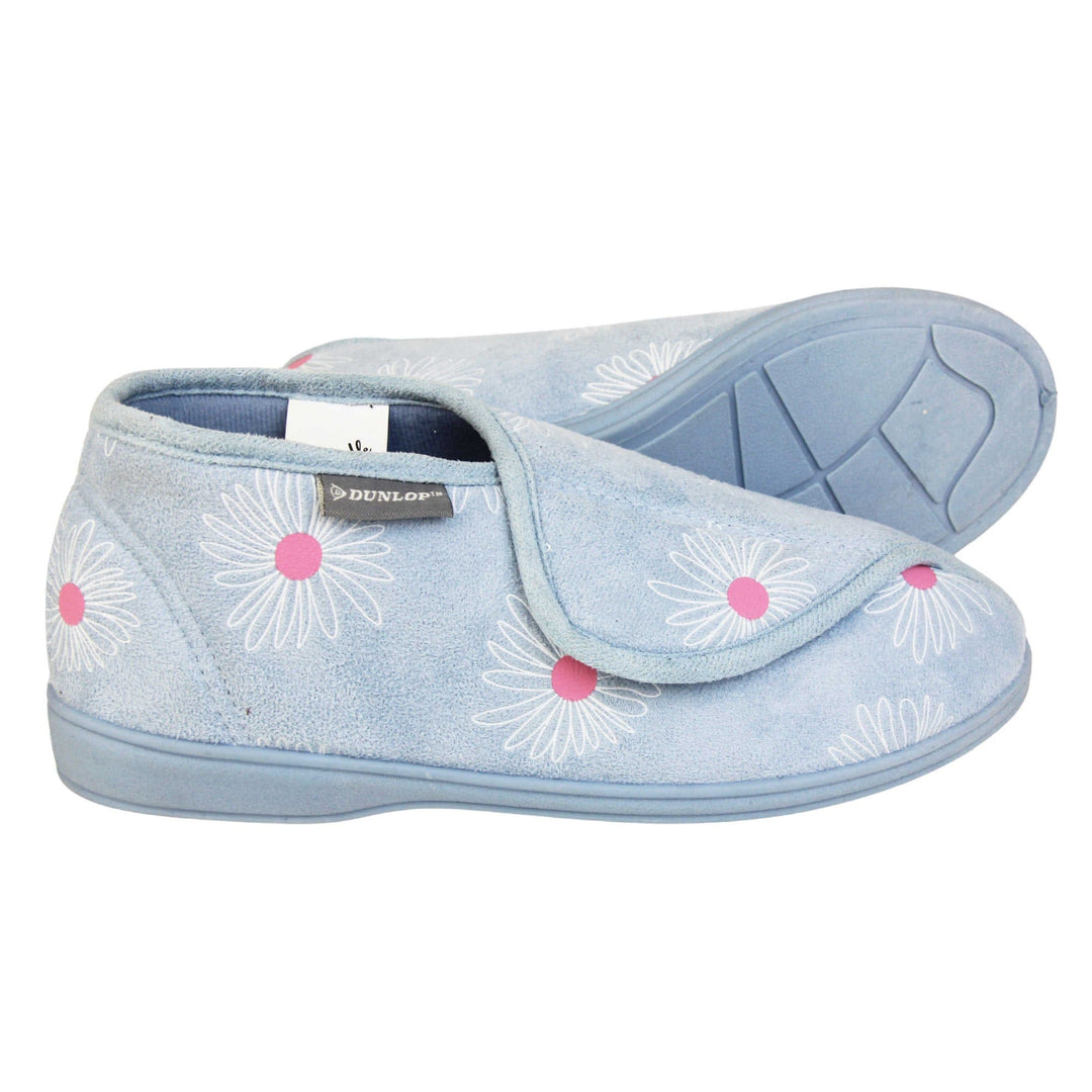 Flower slippers. Womens bootie style slipper with a pale blue textile upper with a white and pink flower print. Touch fasten tab to the top and blue textile lining. Firm blue sole. Both feet from a side profile with the left foot on its side behind the the right foot to show the sole.