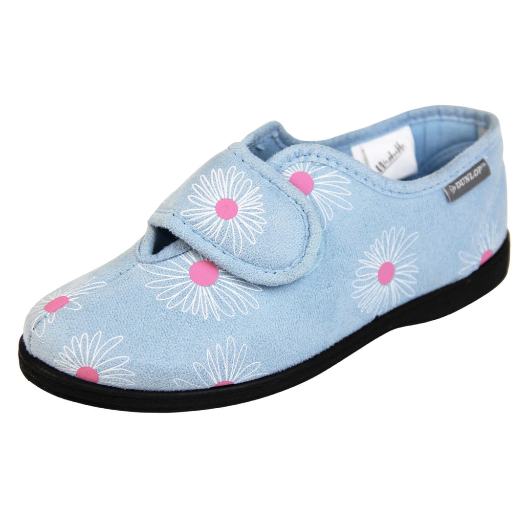 Flower slippers. Womens full back slipper. Pale blue upper with white daisy design and bright pink for the middle of the flowers. Touch fasten strap over the top of the foot to adjust the fit. Matching blue textile lining and firm black sole. Left foot at an angle.