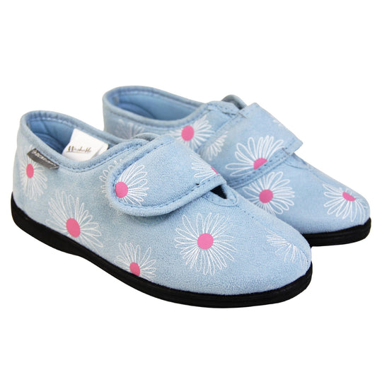 Flower slippers. Womens full back slipper. Pale blue upper with white daisy design and bright pink for the middle of the flowers. Touch fasten strap over the top of the foot to adjust the fit. Matching blue textile lining and firm black sole. Both feet together at an angle.