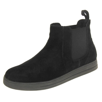 Fur lined ankle boots women's. Chelsea style boot with a black suede upper. Black elasticated panels at the ankles and black faux fur lining. A loop at the heel to help pull them on. Black outsole. Left foot at an angle.