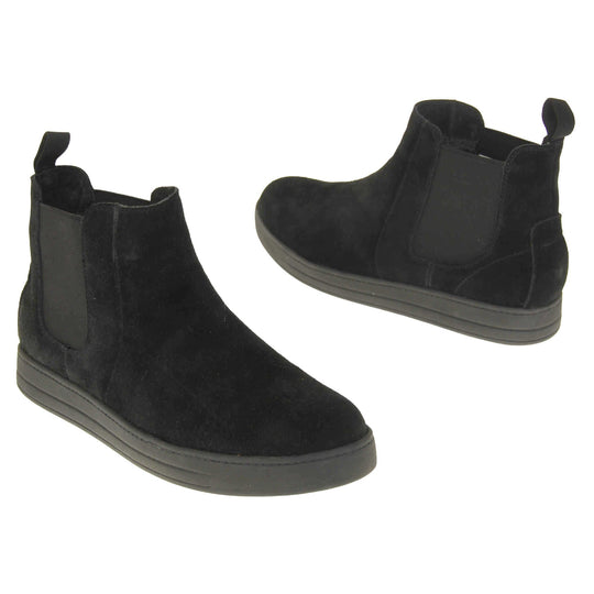 Fur lined ankle boots women's. Chelsea style boot with a black suede upper. Black elasticated panels at the ankles and black faux fur lining. A loop at the heel to help pull them on. Black outsole. Both feet from a slight angle facing top to tail.