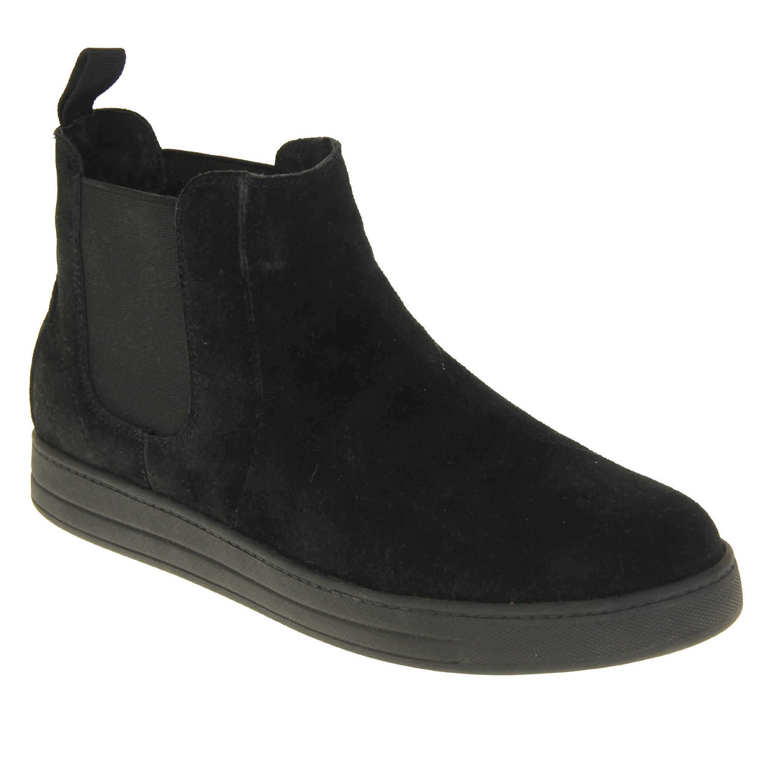 Fur lined ankle boots women's. Chelsea style boot with a black suede upper. Black elasticated panels at the ankles and black faux fur lining. A loop at the heel to help pull them on. Black outsole. Right foot at an angle.