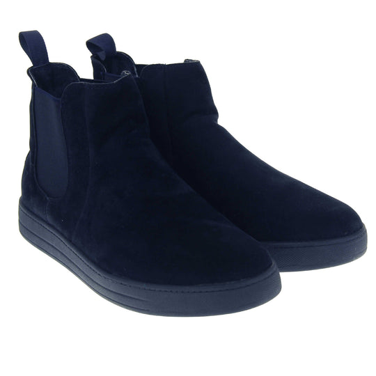 Fur lined Chelsea boots. Women's ankle boot with a navy blue suede upper. Navy elasticated panels at the ankles and navy faux fur lining. A navy loop at the heel to help pull them on. Black outsole. Both feet together from an angle.
