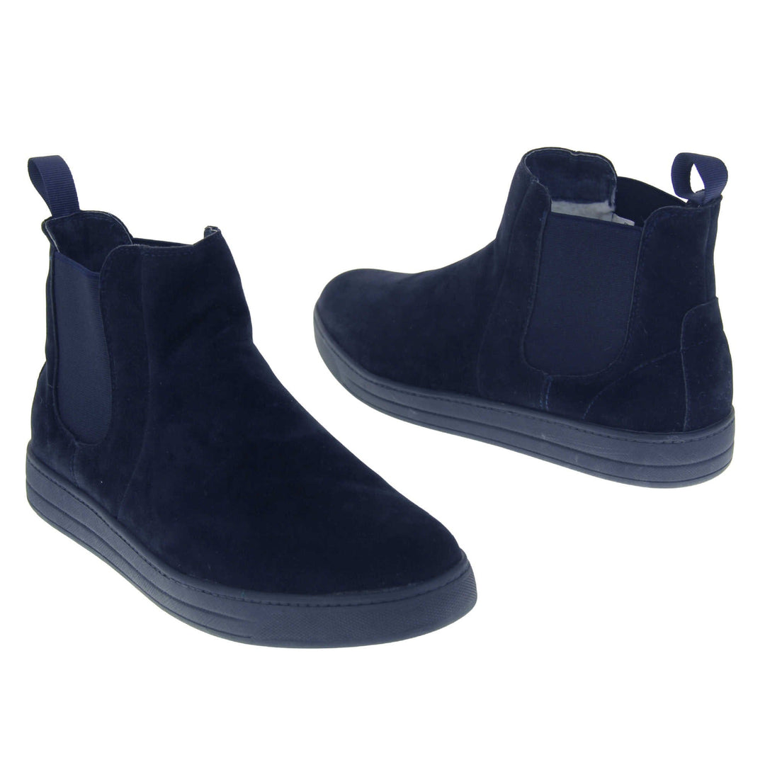 Fur lined Chelsea boots. Women's ankle boot with a navy blue suede upper. Navy elasticated panels at the ankles and navy faux fur lining. A navy loop at the heel to help pull them on. Black outsole. Both feet from a slight angle facing top to tail.