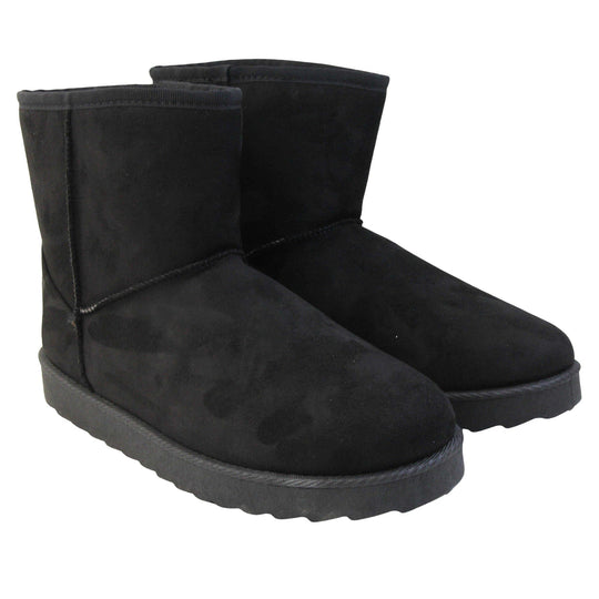 Fur lined winter boots. Ankle boots with a black faux suede upper and stitching detail. Black faux fur lining. Chunky black sole with deep tread to the bottom.  Both feet together from an angle.