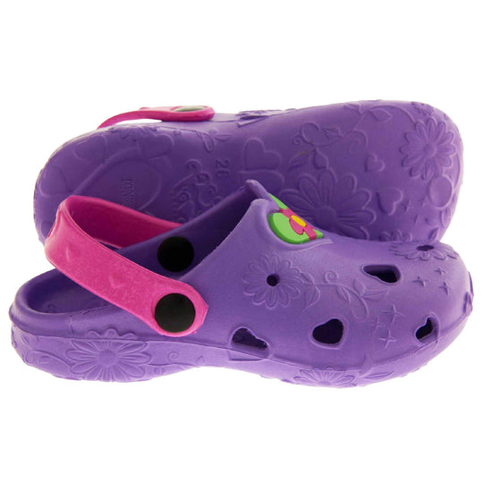 Girls Beach Shoes. Purple synthetic clog style shoes with embossed flowers and stars. Cut out love hearts and centre of flowers on the upper. Green love heart, with pink and yellow flower in the centre, to the middle top of the upper. Pink strap that goes along the back of your heel. The strap can be moved along the top of the shoe instead to make the shoe a mule. Both feet from side profile with left foot on its side to show the sole.