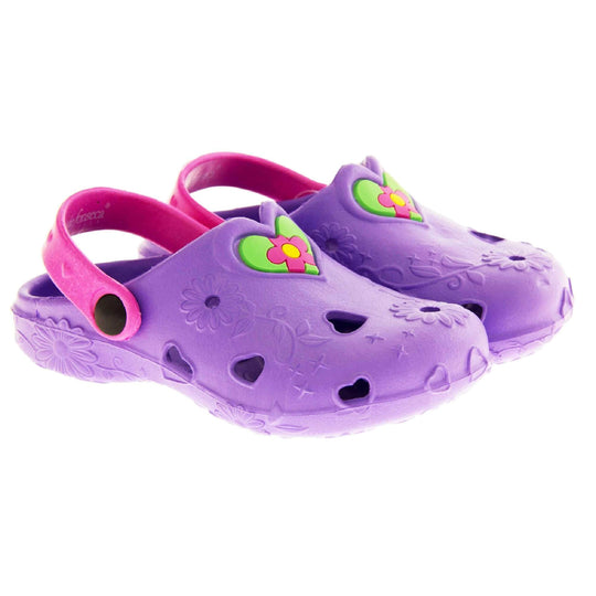 Girls Beach Shoes. Purple synthetic clog style shoes with embossed flowers and stars. Cut out love hearts and centre of flowers on the upper. Green love heart, with pink and yellow flower in the centre, to the middle top of the upper. Pink strap that goes along the back of your heel. The strap can be moved along the top of the shoe instead to make the shoe a mule.  Both shoes next to each other at a slight angle.