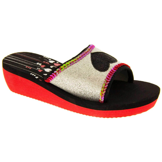 Foam wedge sandals for girls. Red bottom half of the sole with ridges for grip, black top half with red and white heart and line design to the heel of the insole. Silver glitter full strap with black glitter heart in the middle and pink sequins along the edges. Right foot at an angle.