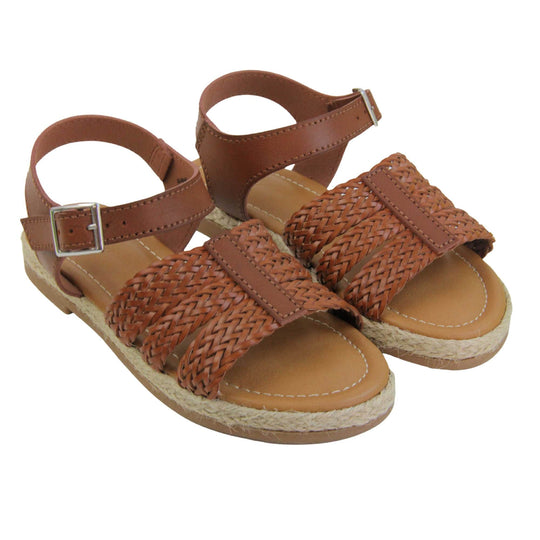 Girls flat sandals. Triple strap sandals with a faux leather dark brown upper. Three woven faux leather straps over the foot with a plain band down the middle. A plain ankle strap with silver buckle. Brown insole with brown lining. Brown outsole with jute rope style rim around the outside. Both feet together at an angle.