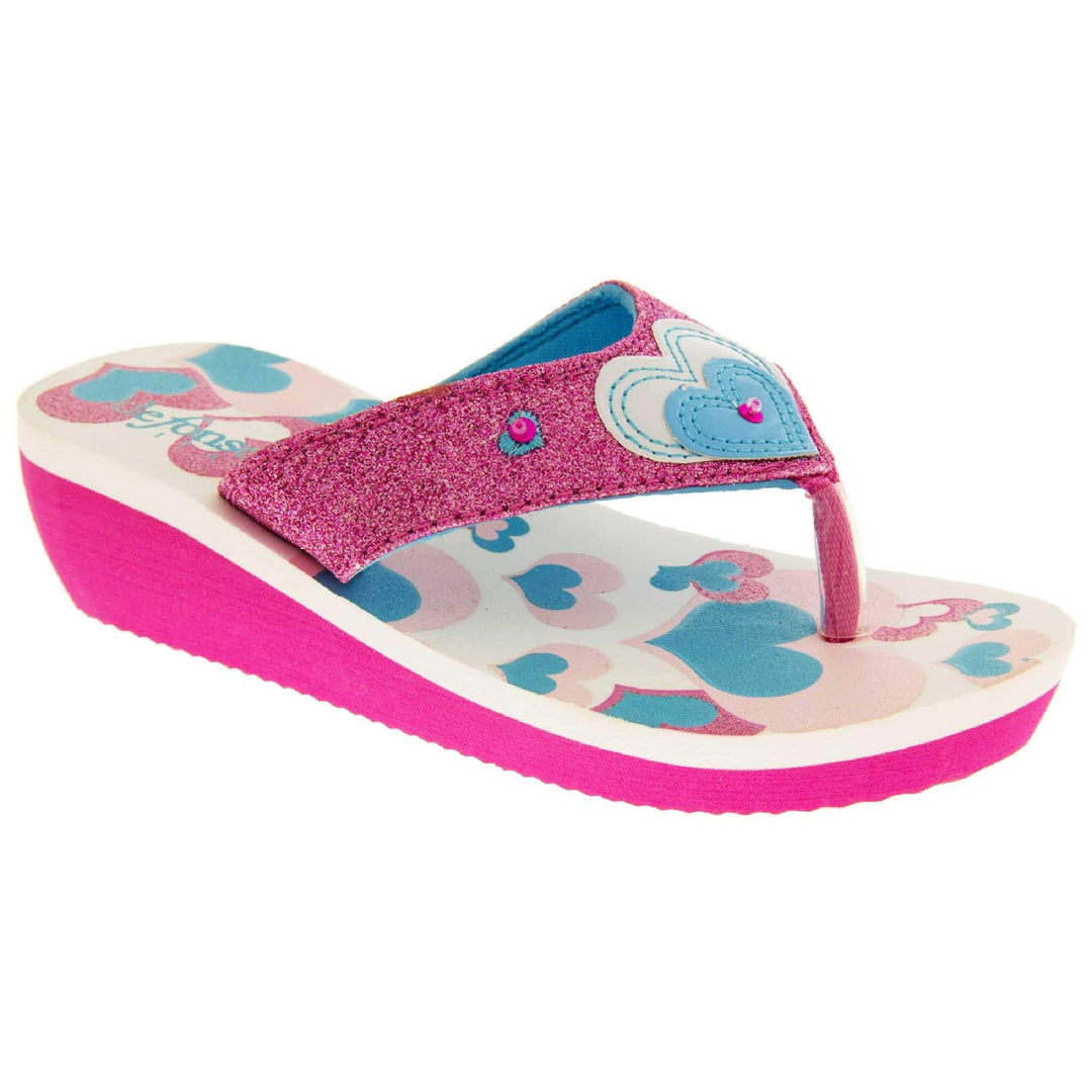 Girls glitter sandals. Foam wedge sandals for girls. Pink bottom half of the sole with ridges for grip, white top half with heart designs in pale pink, bright pink and teal. Bright pink glitter strap with toe-post. With cream and teal heart detail to the strap and pink diamantes. Right foot at an angle.