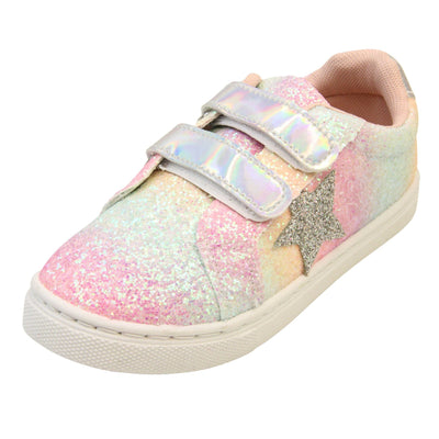 Girls glitter trainers. Kids trainers with a ombre rainbow upper done in glitter. With two silver holographic touch fasten straps. A silver glitter heart detail to the outside of the shoe in the middle of the foot. Pale pink textile lining and chunky white sole. Left foot at an angle.