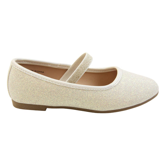 Girls party shoes. Ballerina style shoes with ivory glitter uppers. With a gold glitter elasticated over the foot strap. Cream faux leather collar and beige lining. Dark brown sole with very slight heel. Right foot from a side profile.