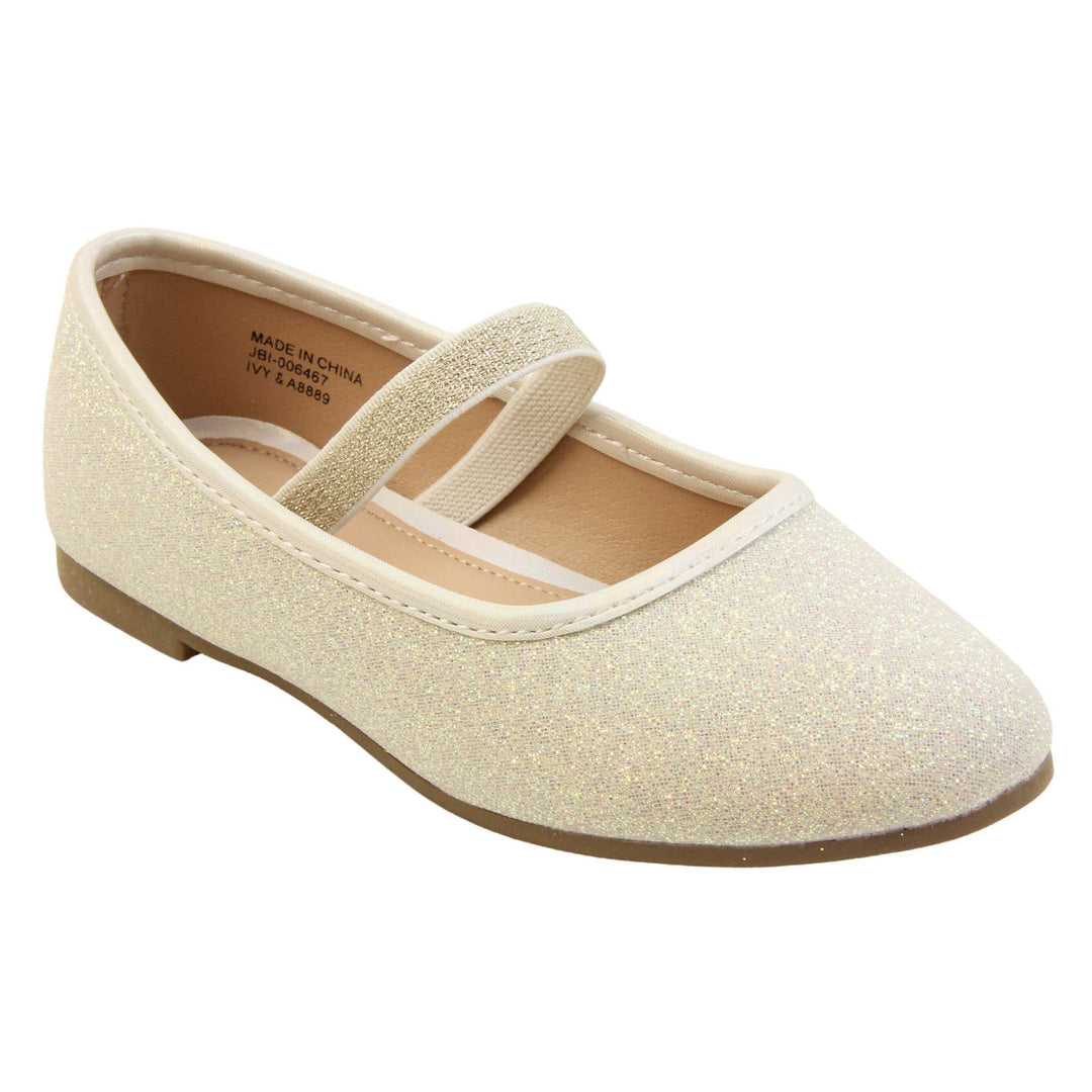 Girls party shoes. Ballerina style shoes with ivory glitter uppers. With a gold glitter elasticated over the foot strap. Cream faux leather collar and beige lining. Dark brown sole with very slight heel. Right foot at an angle.