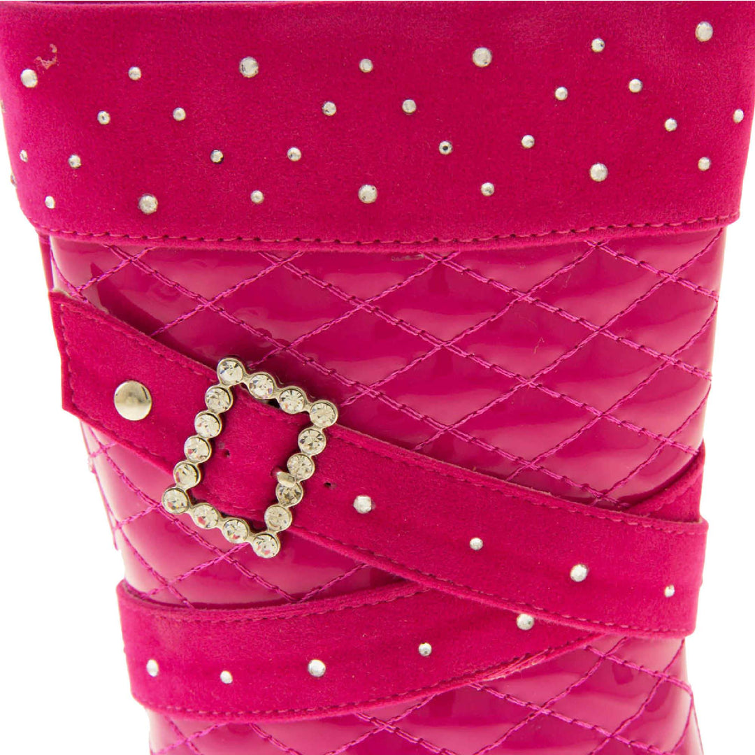 Girls pink boots. Fuchsia patent leather effect uppers with ankle upwards being a quilted style. With faux suede cuff and straps that both have diamantes on. Diamante buckle on the straps. Zip fastening to the inside leg. Black synthetic sole. Close up of the top half of the boots to show the faux suede and diamante detailing and diamante buckle.