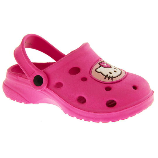 Girls Sandals Pink. Fuchsia pink synthetic clog sandals with holes in the upper. Hello Kitty face in a pale pink circle to the front. Pink strap with black studs to attach to the back of the shoe. The strap can be worn around the back of the heel or over the top of the shoe in a mule. Pink sole with slight heel to the back. Right foot at an angle