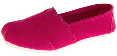 Girls pink shoes. Fuchsia canvas upper with elasticated panel in the middle where the tongue would be. White synthetic sole. Fuchsia textile lining and insole. Left foot at an angle.