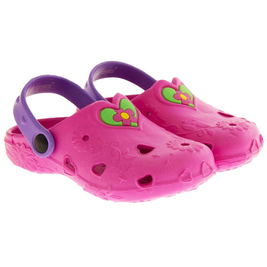 Girls Sandals. Pink synthetic clog style shoes with embossed flowers and stars. Cut out love hearts on the upper. Green love heart, with pink and yellow flower in the centre, to the middle top of the upper. Purple strap that goes along the back of your heel. The strap can be moved along the top of the shoe instead to make the shoe a mule.  Both shoes next to each other at a slight angle.