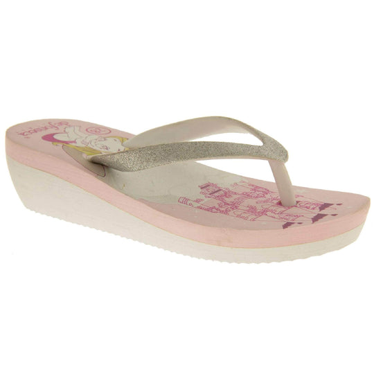 Foam wedge sandals for girls. White bottom half of the sole with ridges for grip, baby pink top half with bright pink fantasy design to the insole. White strap with toe post covered on top with pale gold glitter. Right foot at an angle.
