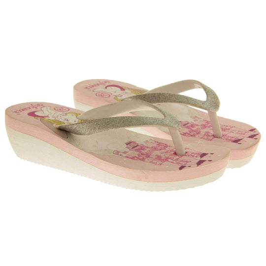 Foam wedge sandals for girls. White bottom half of the sole with ridges for grip, baby pink top half with bright pink fantasy design to the insole. White strap with toe post covered on top with pale gold glitter.  Both feet next to each other at an angle.