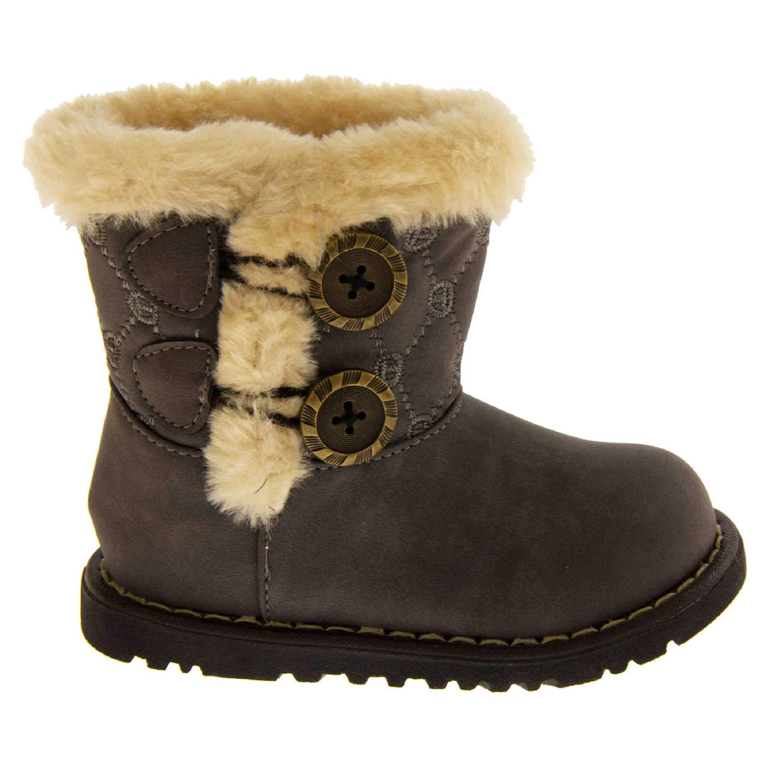 Girls Winter Boot Infant Sizes. Grey faux suede with chunky black sole and cream fur trim around rim and down the side of the boot. 2 buttons on the side with the fax fur as detailing. Right foot from the side