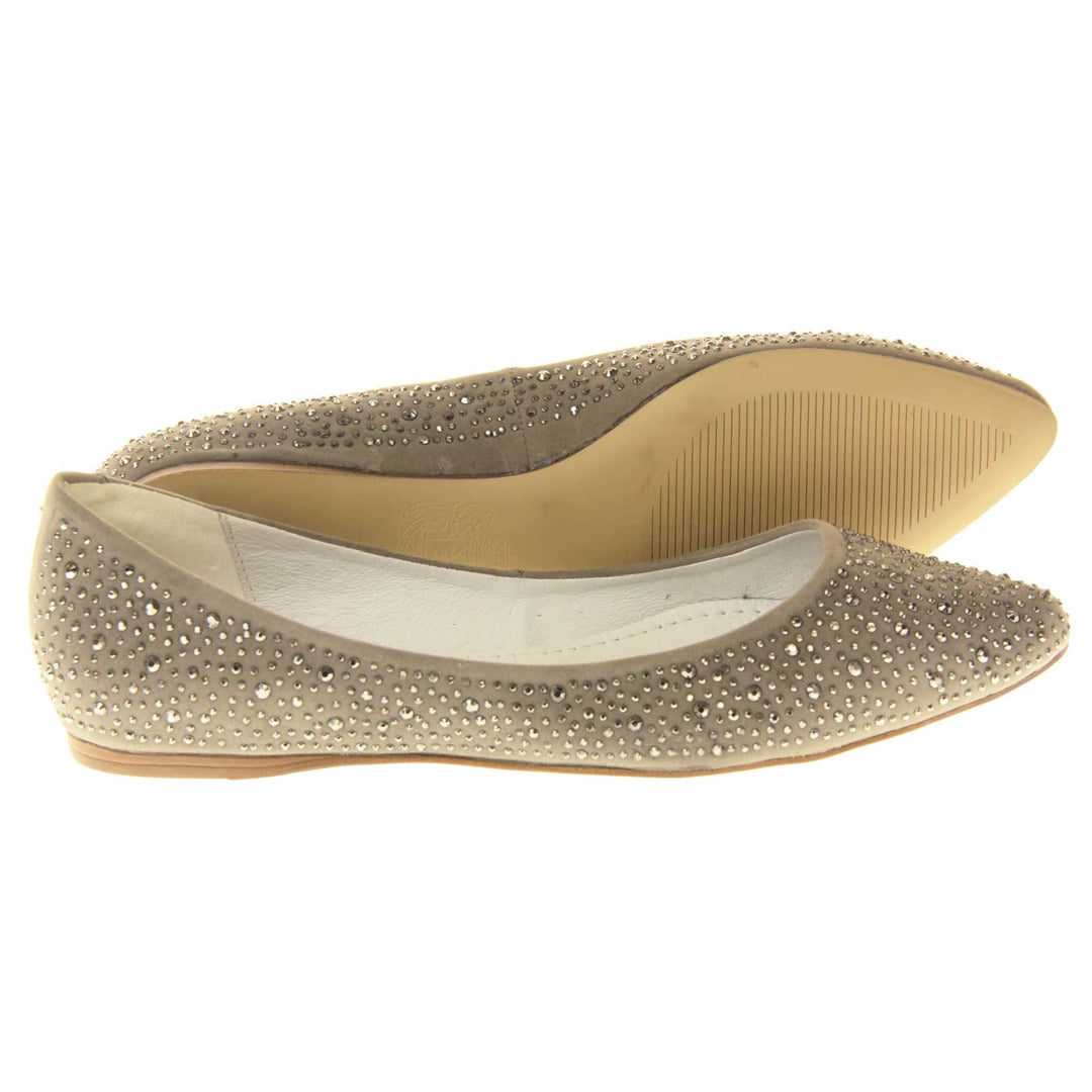 Gold flat pumps. Ballet style shoes with a taupe faux suede upper covered in gold diamantes. Cream leather lining and beige sole. Both feet from a side profile with the left foot on its side behind the the right foot to show the sole.